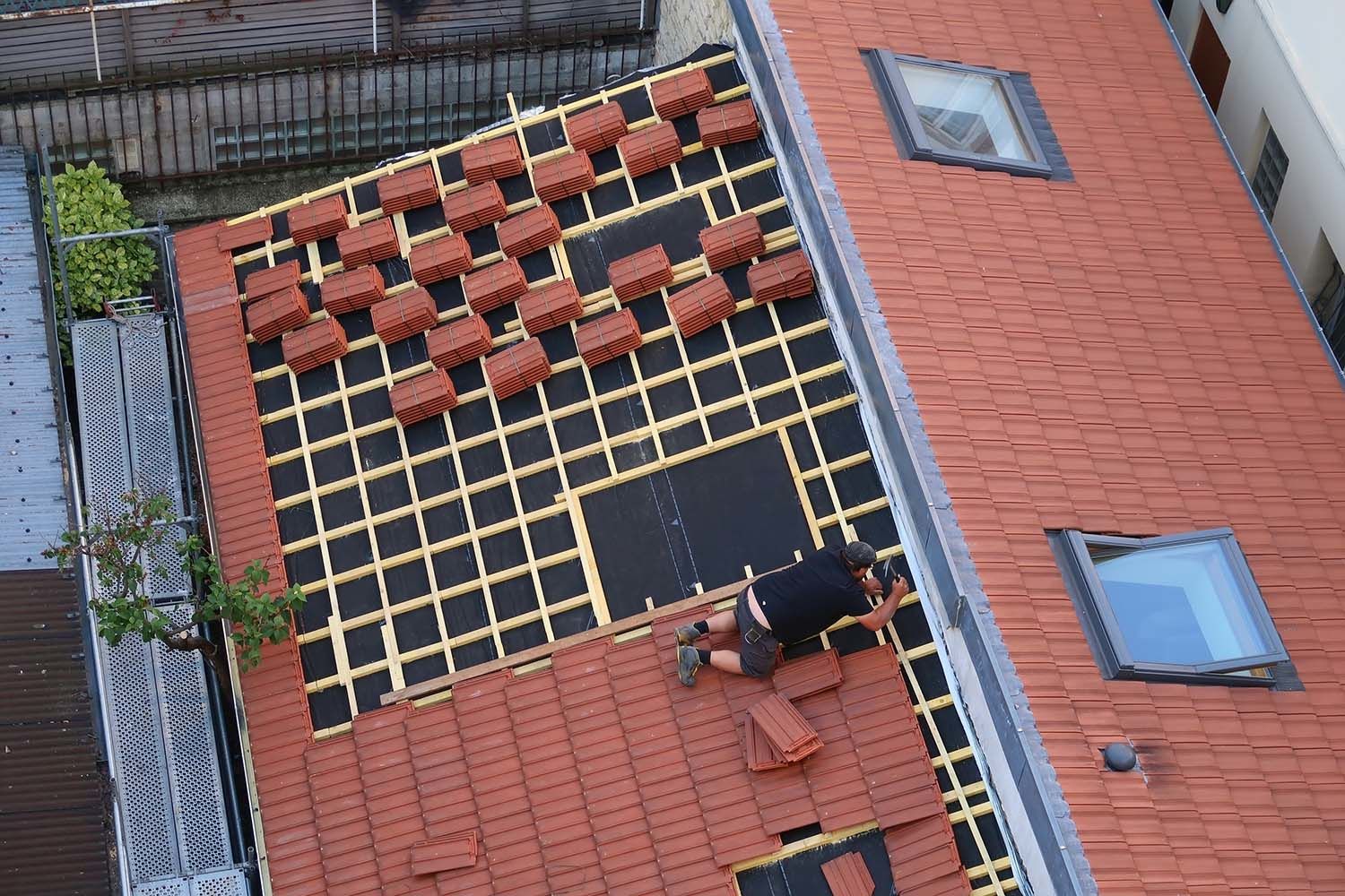 Couvreur posant des tuiles sur le toit d'une maison